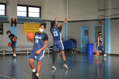 Gary Bailey, 9th grade guard, warms up with the boys varsity basketball team.