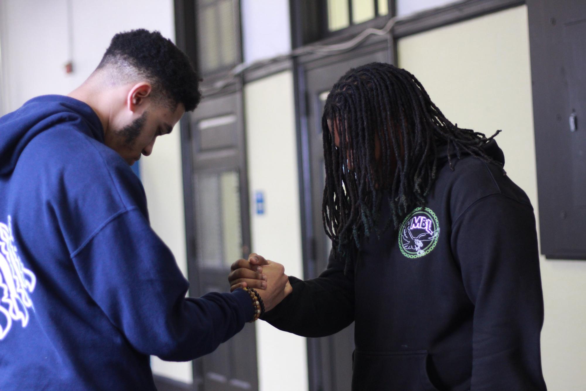 Charles giving Jadon a firm handshake, working together as a musical duo.